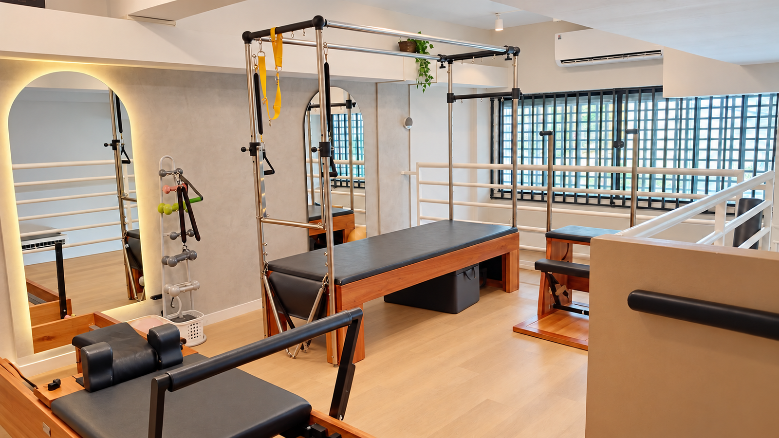 Vista ampla do estúdio Balans com aparelhos de Pilates e janelas